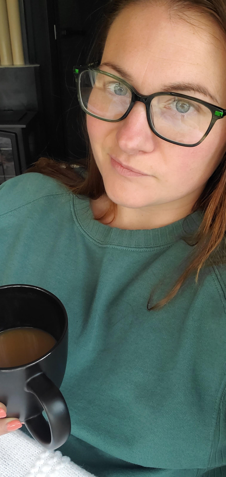 Kristen, founder of Steady Ground, holding a mug of coffee at home